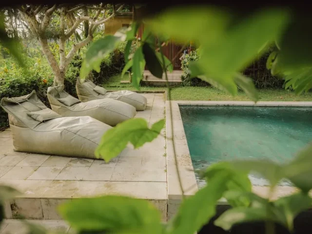Daybed beside the pool with lotus leaves at Villa Lumbung Temesi