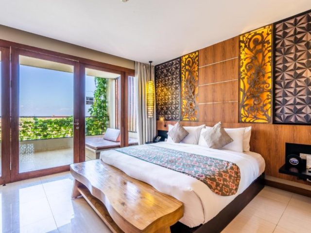 Guest suite interior with a bed and wood accents at Vouk Hotel & Suites