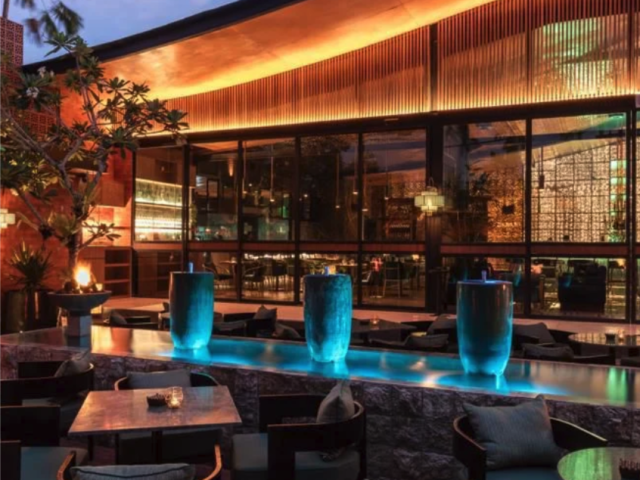 Warmly lit dining area with blue banquette seating at Jade restaurant