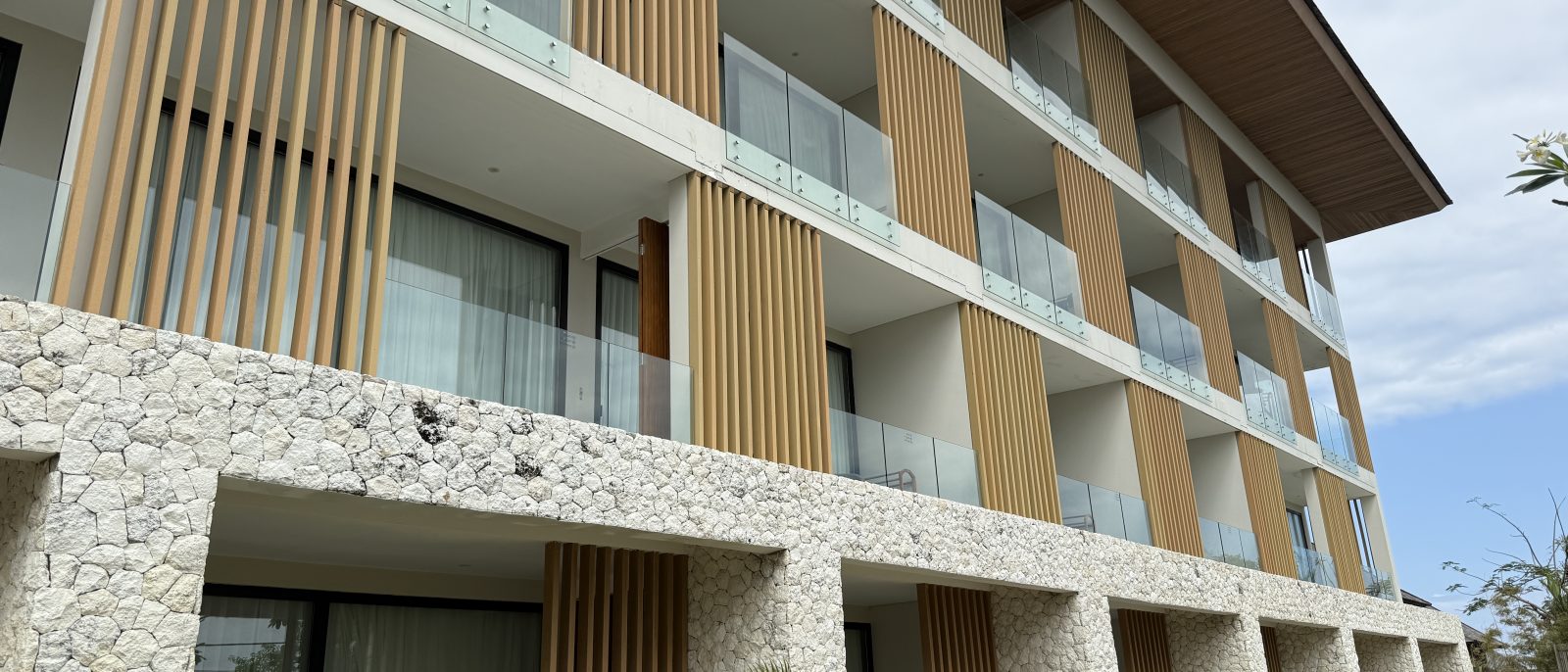 Exterior of the apartment building with a stone and timber façade at Karma Kandara