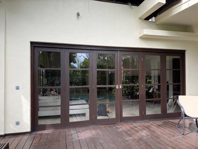 Renovated interior room with dark-framed glass doors at Karma Kandara